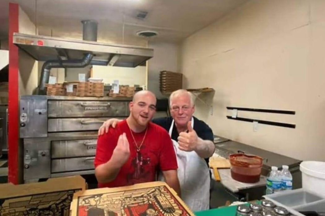 Two members of the Labella's team behind the counter in front of the pizza ovens
